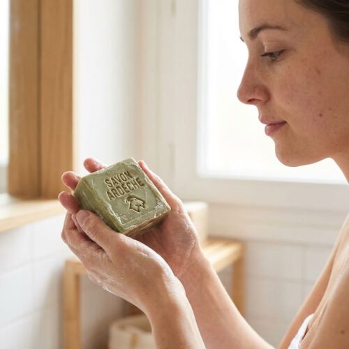 Savon d’Ardèche tenu dans les mains avec mousse légère et texture naturelle