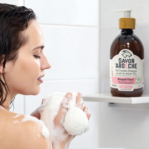 Femme se savonnant sous la douche avec un gel douche artisanal