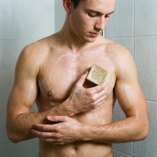 Homme utilisant un savon au lait de chèvre enrichi à l’huile de chanvre Savon d’Ardèche sous la douche