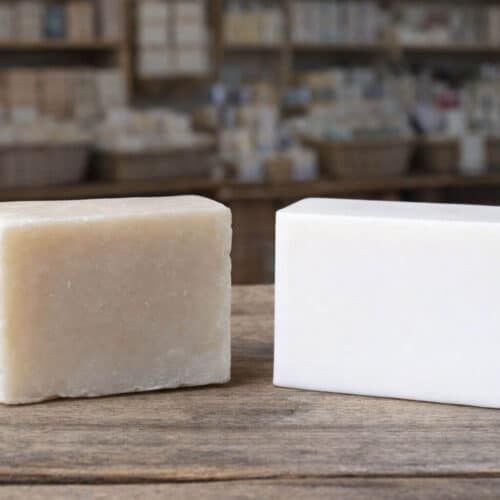 Comparaison entre un savon au lait de chèvre artisanal mat aux bords irréguliers et un savon lisse aux angles nets dans une boutique de savons.