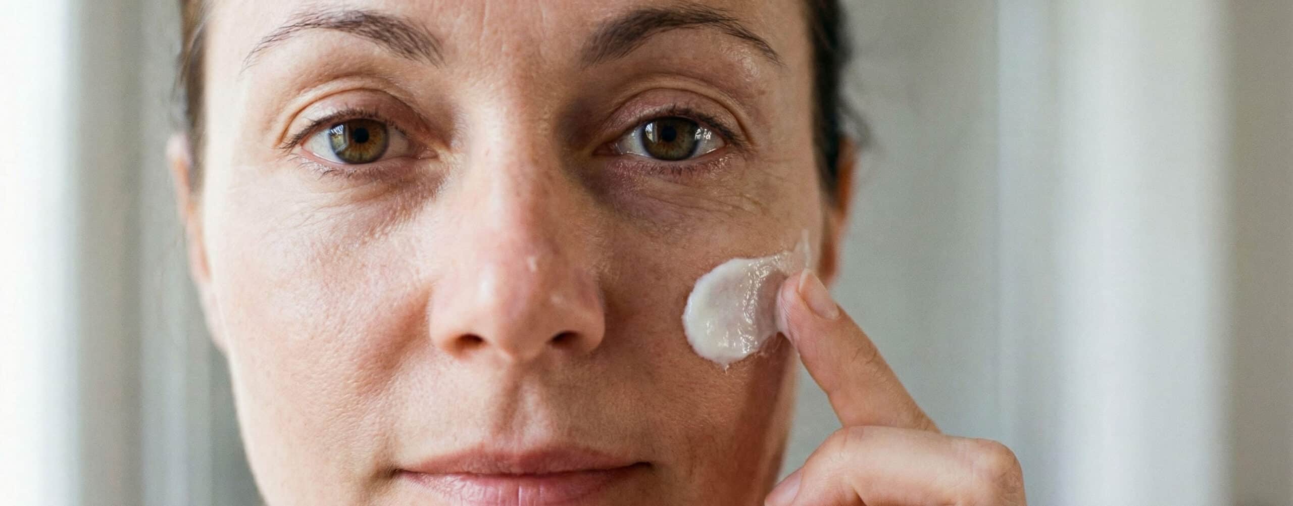 Gros plan sur la texture d’une crème visage au lait de chèvre appliquée sur une peau mature